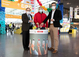 Geschäftsführer Stefan Lohnert (links) mit Walter Schoefer (rechts), Sprecher der Geschäftsführung der Flughafen Stuttgart GmbH und Martin Grunenberg, stellvertretender Geschäftsführer und Verwaltungsleiter bei Trott-war, vor der Pfandstation.